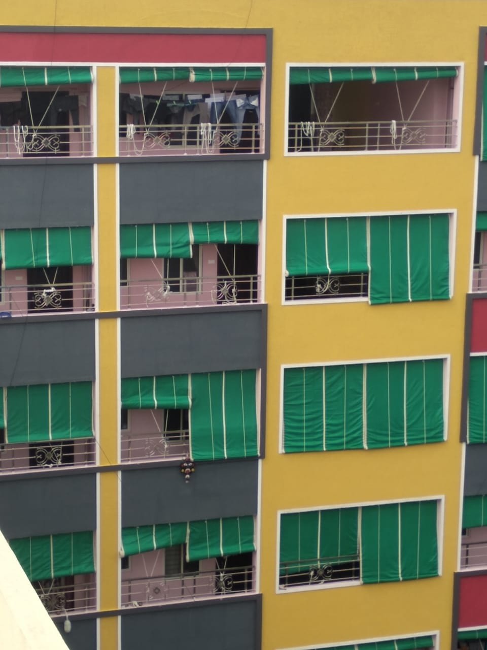 Green balcony shade nets installed across apartment block